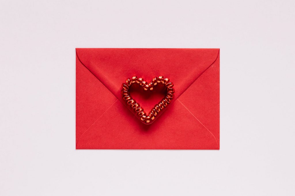 colorful gift envelope with heart on pink background