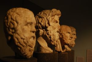 Image of philosophy statues on a pedistal.