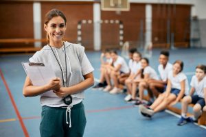 Young,Happy,Female,Coach,Looking,At,Camera,While,Having,Pe