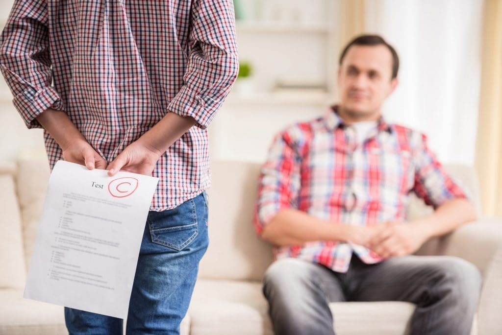 young boy hiding test score