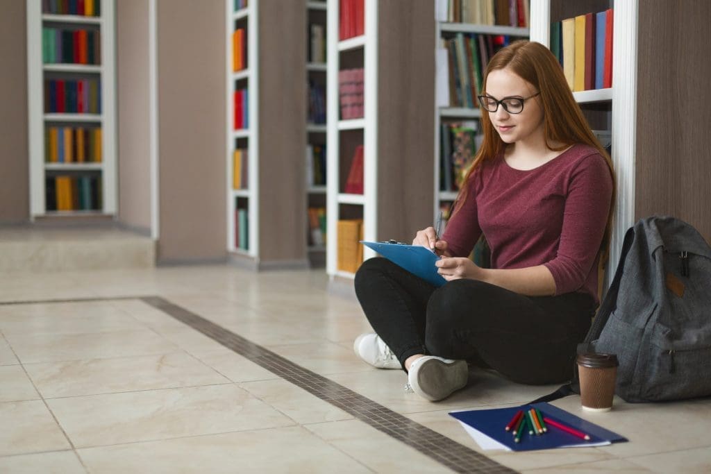student sitting on the library floor