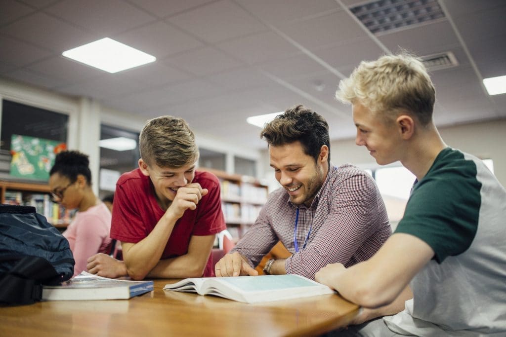 student engaging with their teacher at the library