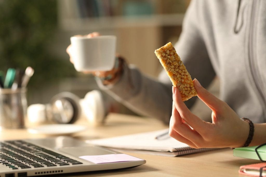student holding a coffee and snack