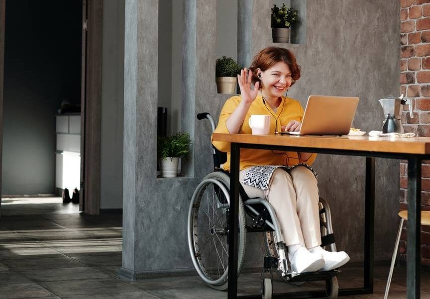woman in orange tank top sitting on black wheelchair