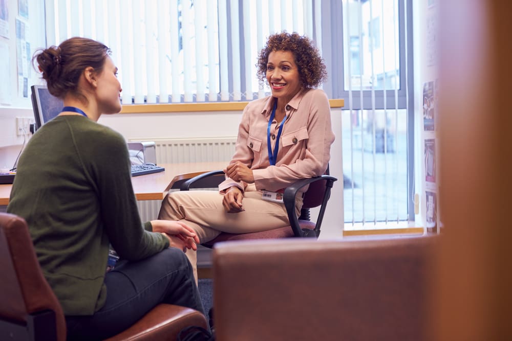 College career counselor meeting with a student in her office to plan internships for college freshmen.