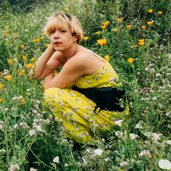 Empowerly Counselor Jennifer in yellow surrounded by yellow flowers