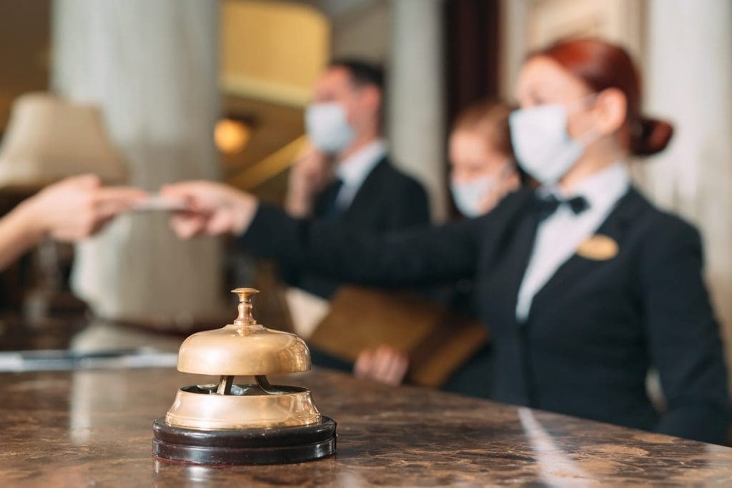 Check,In,Hotel.,Receptionist,At,Counter,In,Hotel,Wearing,Medical