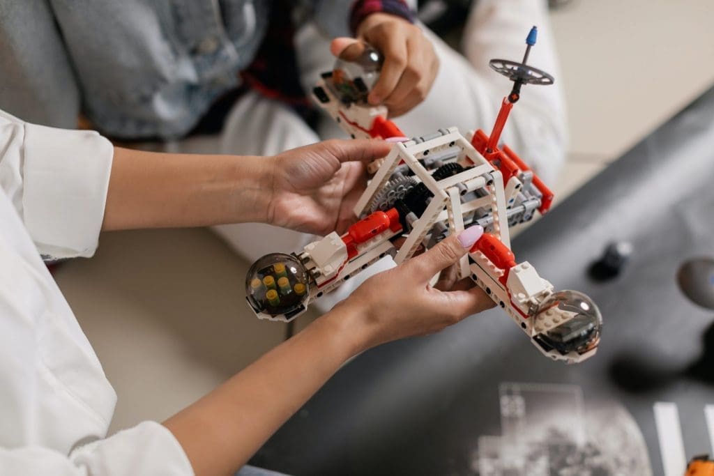 Two individuals building a robot