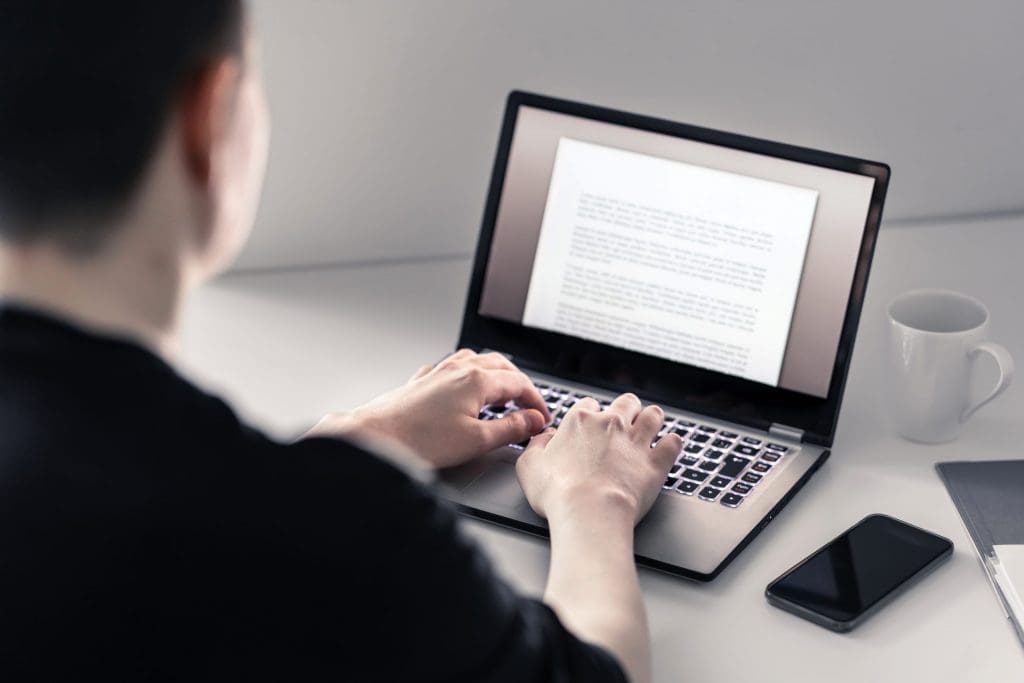 man writing on laptop