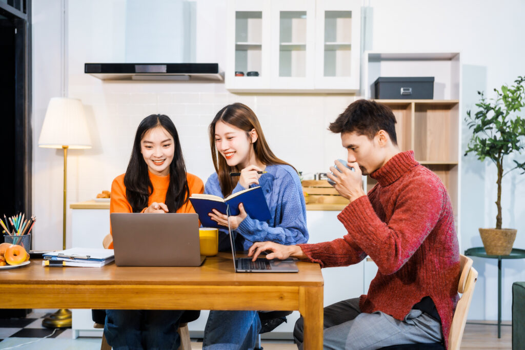 Trio of high school students work on computer devices to study for 2025 SAT prep