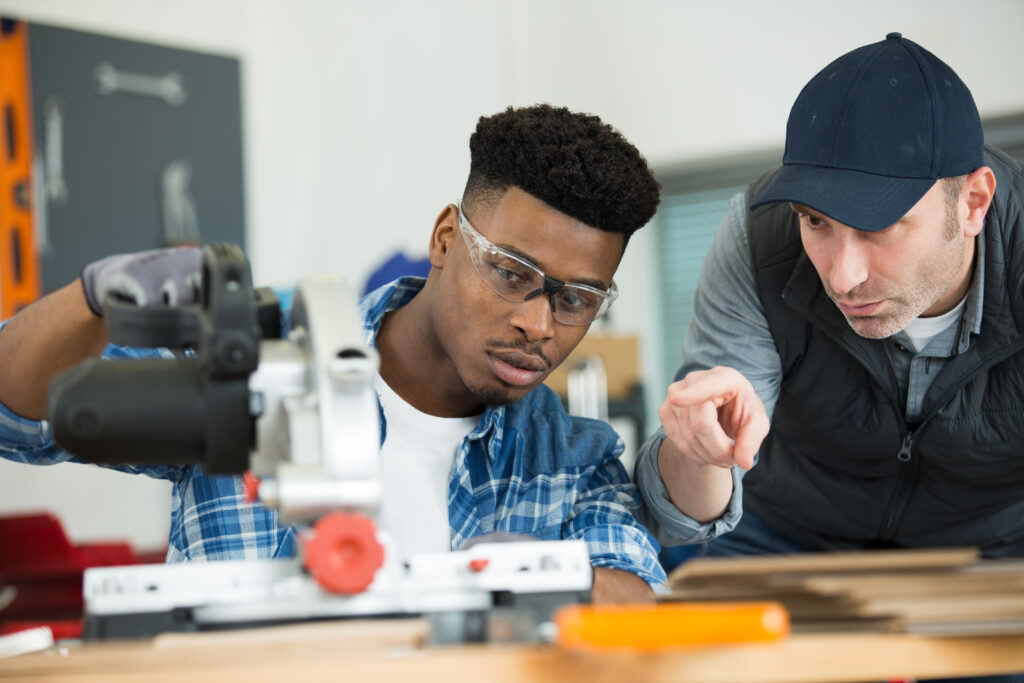 Teacher and student working closely on a technical project.