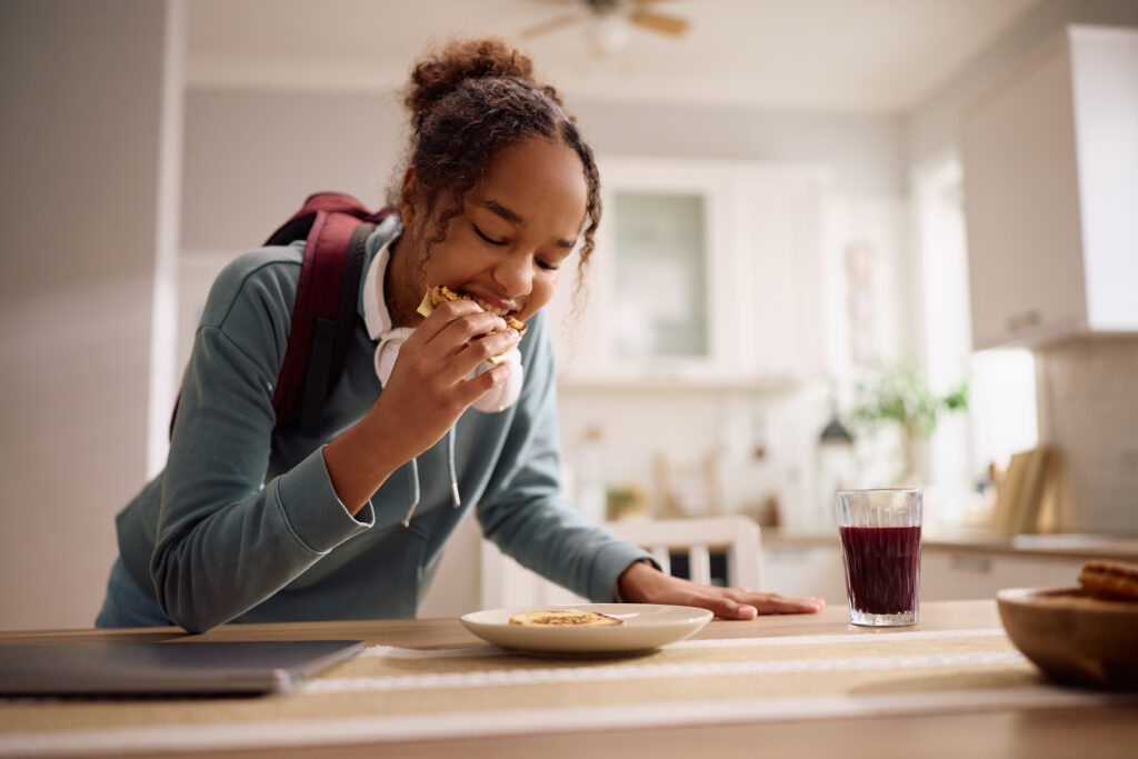 High school student eating a nutritious breakfast before school