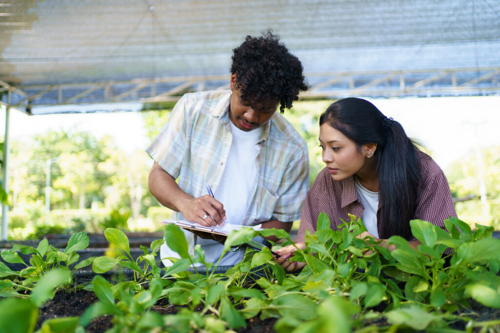 Two biology majors work in a greenhouse